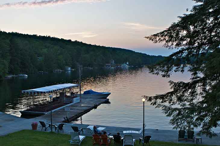 A row of lawn chairs looking out onto a sunset over the Delaware River